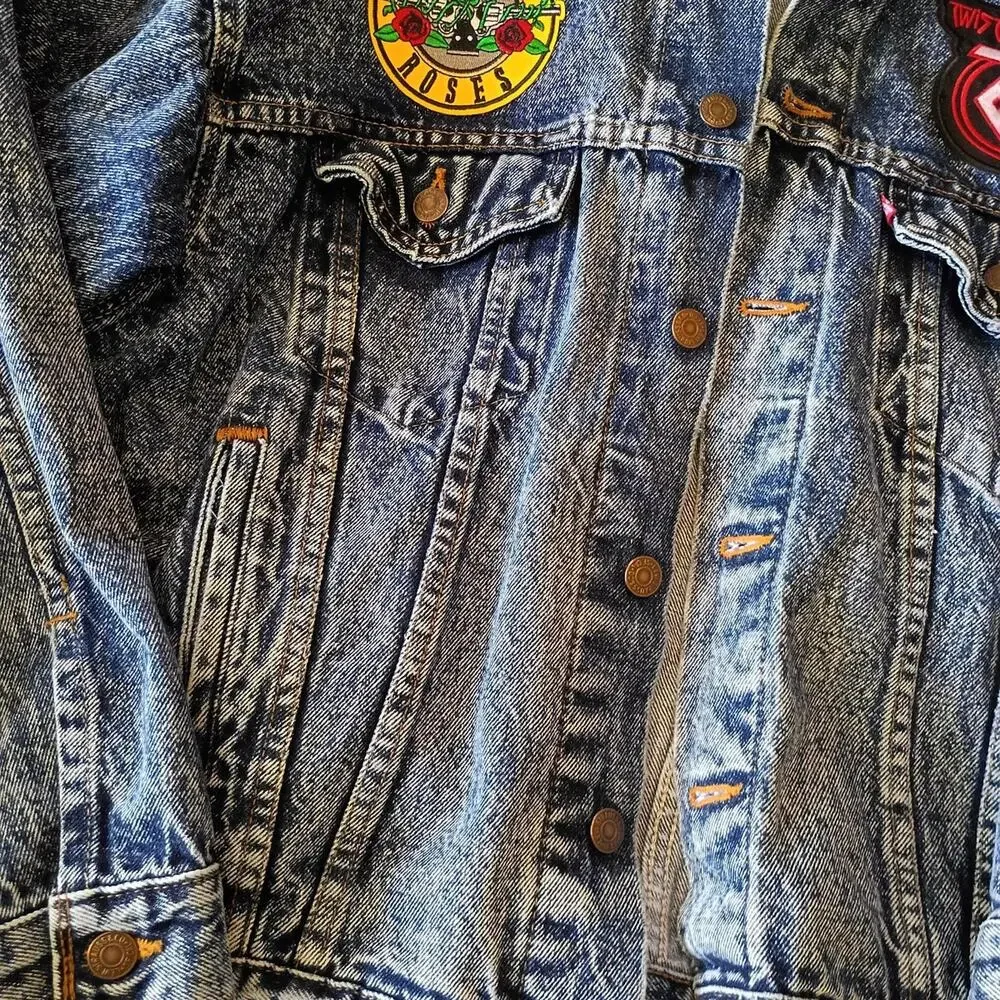 Vintage 1980'S Levi's jean jacket with rock band patches on it. Size large.